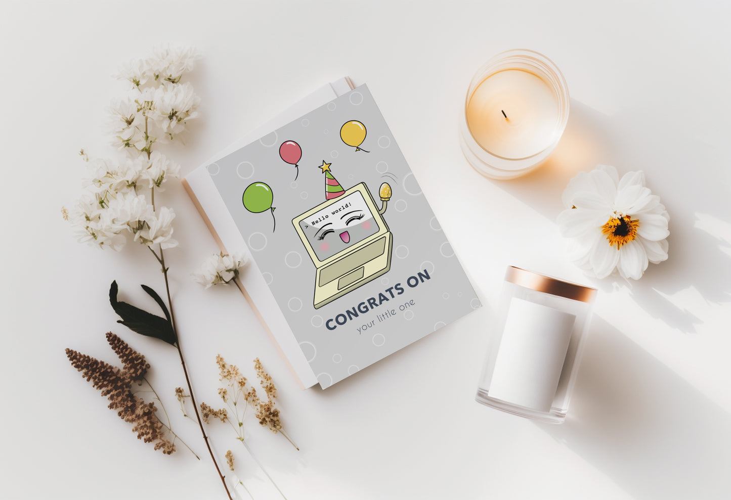 A kawaii greeting card from Rainbow & Bubbles, showing a laptop displaying Hello world! Baby Laptop is celebrating the birth of a baby. The front says "Congrats on your little one".
