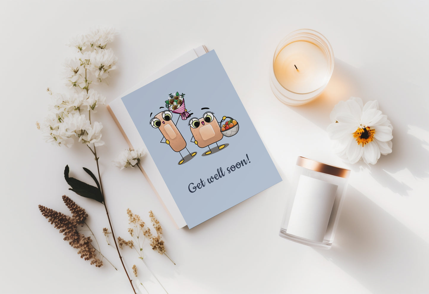 A kawaii greeting card from Rainbow & Bubbles, showing two kawaii bandages holding a flower bouquet and a fruit basket, with the text Get Well Soon.