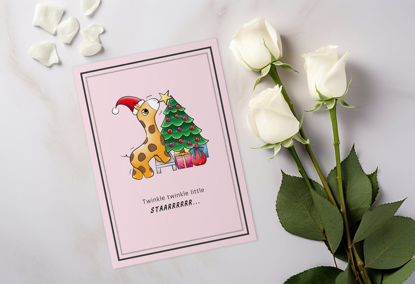 A kawaii greeting card from Rainbow & Bubbles, showing a baby giraffe with. santa hat struggling to put the star on the Christmas tree.