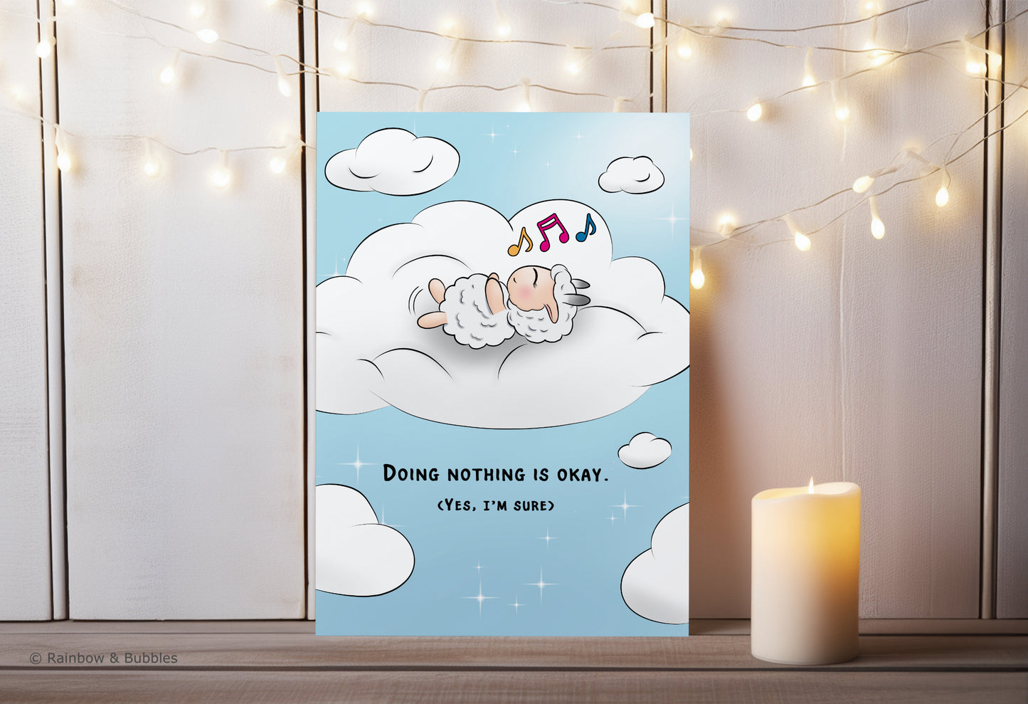A kawaii greeting card from Rainbow & Bubbles, showing a sheep doing nothing, simply relaxing in a bed of cloud and humming his favorite tune.