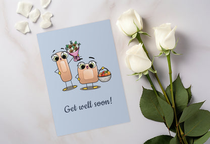 A kawaii greeting card from Rainbow & Bubbles, showing two kawaii bandages holding a flower bouquet and a fruit basket, with the text Get Well Soon.