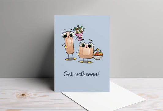A kawaii greeting card from Rainbow & Bubbles, showing two kawaii bandages holding a flower bouquet and a fruit basket, with the text Get Well Soon.