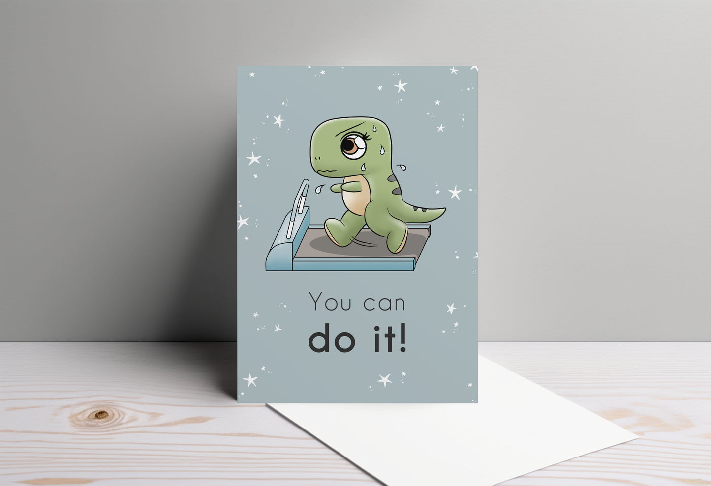 A kawaii greeting card from Rainbow & Bubbles, showing a t-rex running and sweating on the treadmill. The front says "You can do it!"