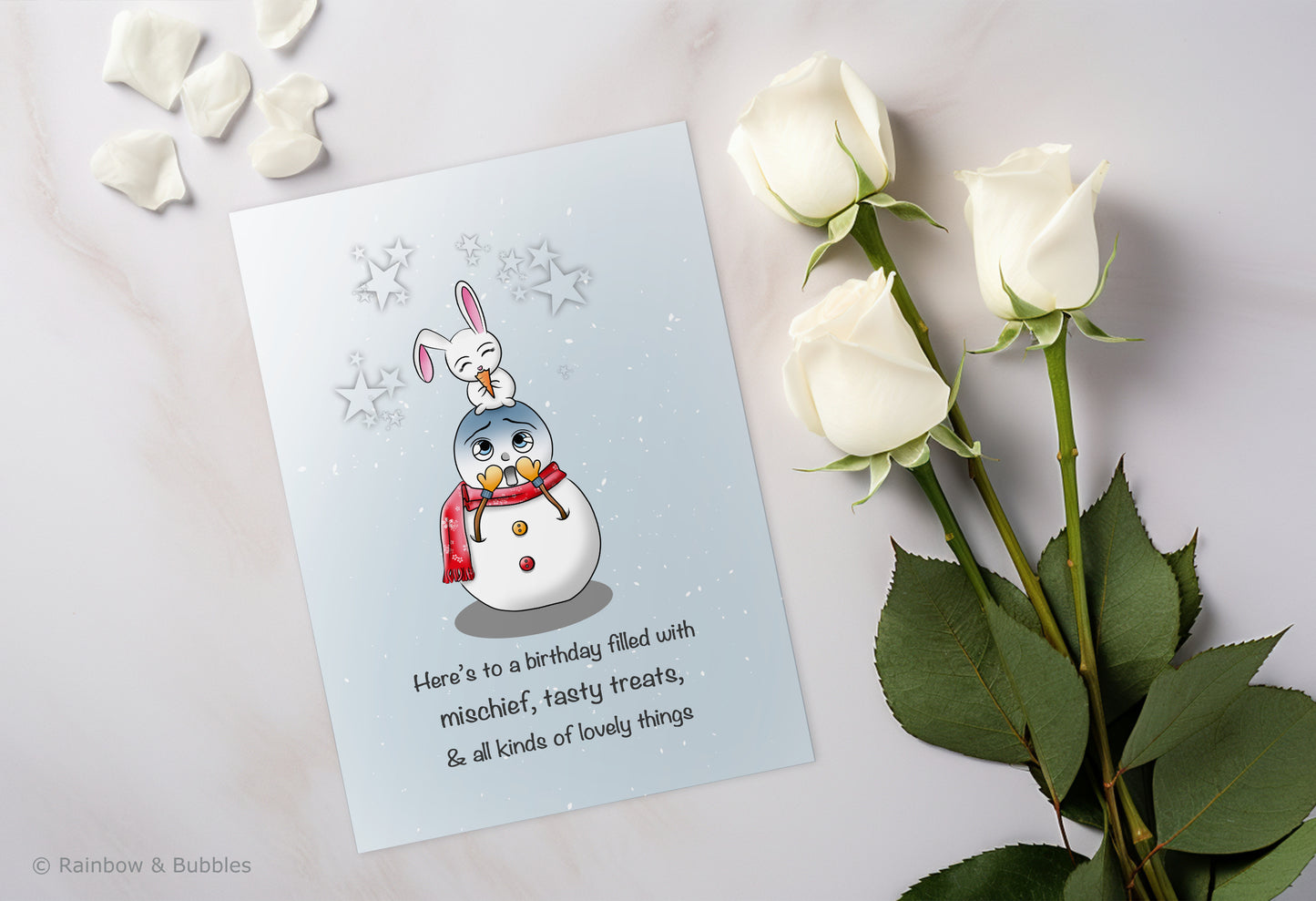 A kawaii birthday card from Rainbow & Bubbles, showing a mischievous bunny eating a tasty treat (the snowman's nose).