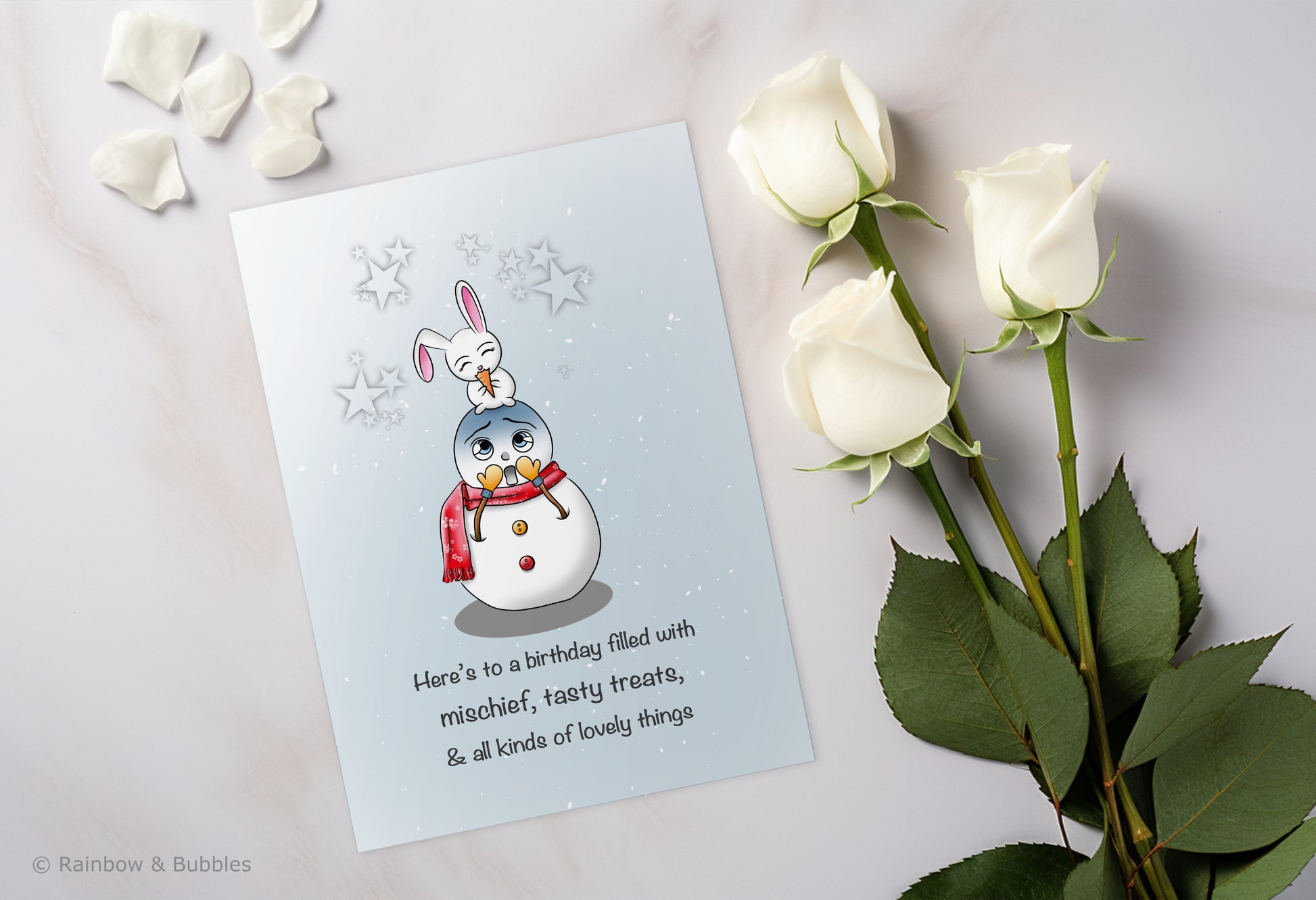 A kawaii birthday card from Rainbow & Bubbles, showing a mischievous bunny eating a tasty treat (the snowman's nose).
