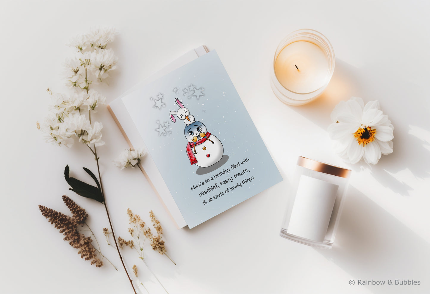 A kawaii birthday card from Rainbow & Bubbles, showing a mischievous bunny eating a tasty treat (the snowman's nose).